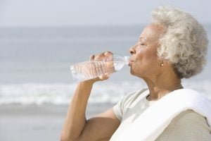 Senior Woman Drinking Water on Beach_Sunscape™ Boca Raton