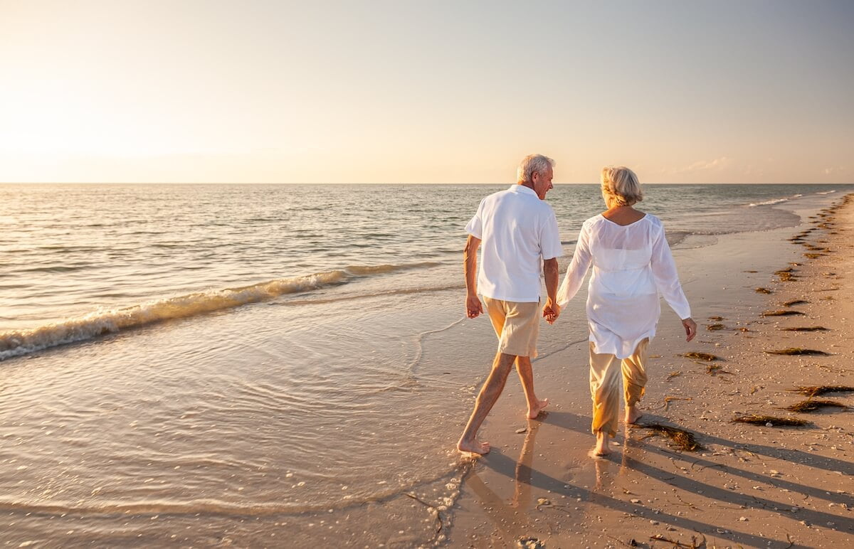 Top 5 Reasons to Retire in Boca Raton, Florida Couple of seniors holding hands and walking on the beach