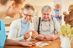 3 Benefits of Co-Living in Memory Care in Boca Raton Happy seniors putting a puzzle together