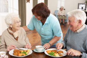 What to Look for During an Assisted Living Tour in Boca Raton Couple of seniors being served their meal by a caregiver