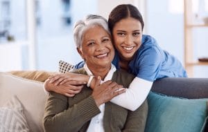 How Senior Living in Boca Raton Empowers Older Adults Caregiver hugging a senior woman.