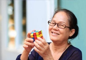 What is Holistic Wellness, and Why Does it Matter? Older woman solving a Rubik's cube