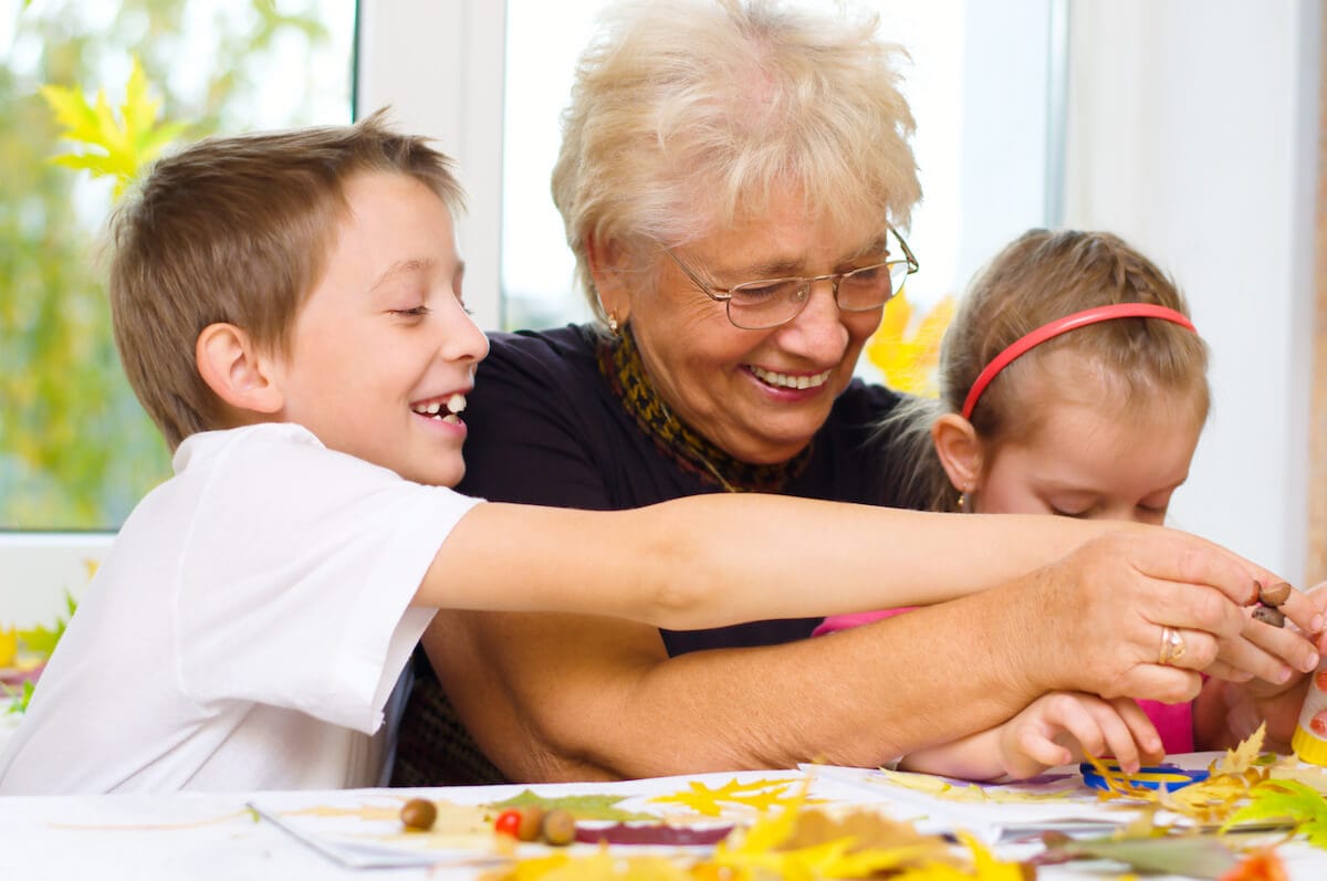Grandmother crafting a vision board with grandchildren.