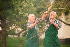 6 Benefits of Gardening for Older Adults Couple of happy seniors watering their plants together
