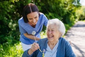 Women and Dementia: What Makes It Unique? Caregiver with an older woman holding a flower