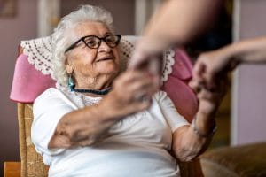 Women and Dementia: What Makes It Unique? Older woman with dementia holding hands with a relative
