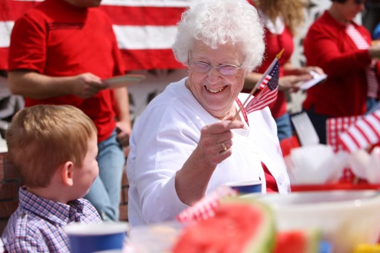 Smiling older woman celebrating 4th of July with her grandson