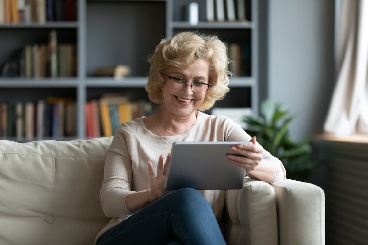 Why Lifelong Learning is Important in Retirement Older woman happily using a tablet