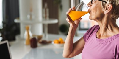 Senior Woman Drinking Orange Juice_Retirement Community in Boca Raton